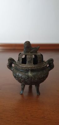 a small metal object sitting on a wooden table