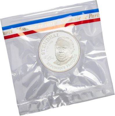 a close up of a coin in a plastic bag on a white background