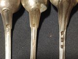 three spoons that are sitting on a table