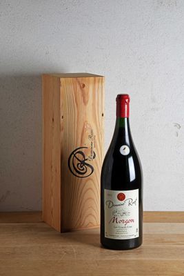 une bouteille de vin posée à côté d'une caisse en bois