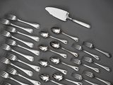 a lot of silver spoons and forks on the table