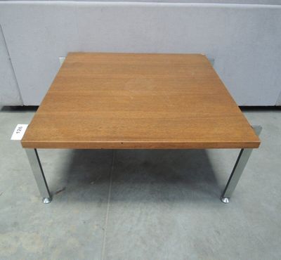 une table basse en bois avec des pieds en métal posée sur un sol carrelé