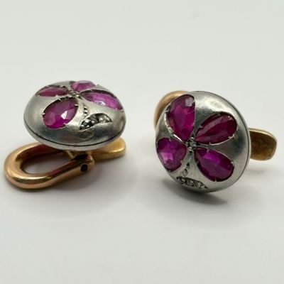deux paires de boutons de manchette en argent sertis de pierres roses, posés sur un fond blanc