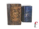 two old books sitting next to each other on a white surface