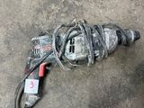 a drill that is laying on the ground next to a cord