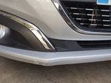 the front end of a silver car with a number plate on it