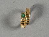 l'image d'une bague en or ornée d'une pierre verte