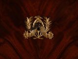 an image of a gold and black bird on a red velvet background
