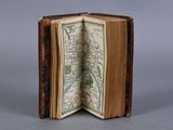 an open book with a map inside of it sitting on a table