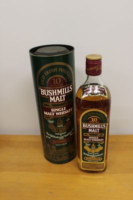 the bottle of bushmills malt is next to a canister