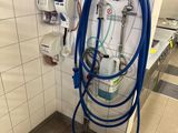 un tuyau bleu fixé au mur dans des toilettes publiques