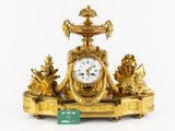 a gold clock that is sitting on top of a table