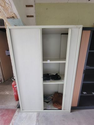 une armoire blanche avec une porte et des étagères dans une pièce