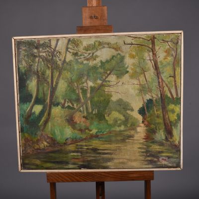 une peinture à l'huile posée sur un chevalet, avec une rivière au premier plan