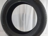 a close up of a tire on a white surface with a curtain behind it