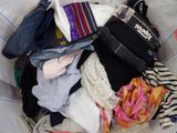 a basket full of clothes that is sitting on a bed