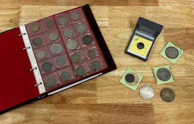 un livre avec des pièces de monnaie et une calculatrice à côté