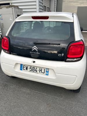 une petite voiture blanche garée dans un parking