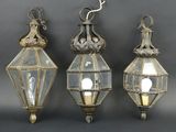 trois lanternes en verre suspendues au plafond sur un fond gris