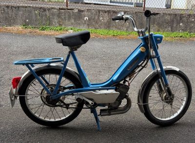 a blue motor bike parked on the side of the road