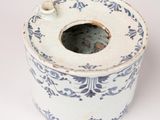 a white and blue vase with a hole in it