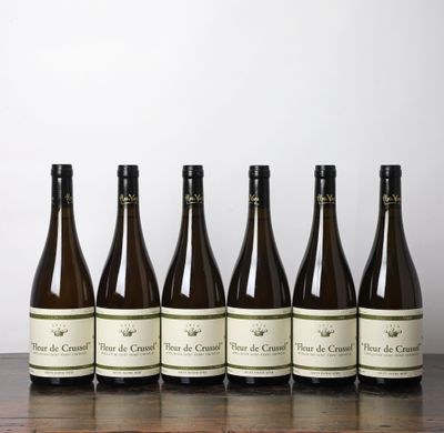 six bouteilles de vin sont alignées sur une table en bois