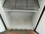 a small refrigerator that has a lot of food inside of it