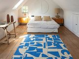 un tapis bleu et blanc au milieu d'une pièce