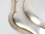 une assiette en argent posée sur une table blanche, avec une banane dessus