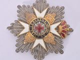 an image of a silver and gold broochle with a red cross on it