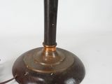 a black and gold lamp on a table with a white background