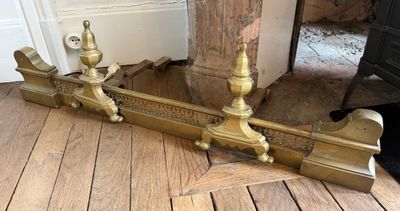 une paire de bougies en laiton posées par terre près d'une porte