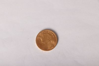 a small coin on a white surface with a white background
