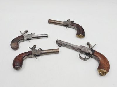trois vieux revolvers posés sur une surface blanche, sur fond blanc