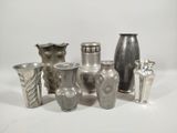 a lot of silver vases sitting on a white surface