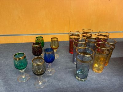 many different colored glasses sitting on a table