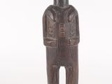 an old wooden statue of a man standing on top of a wooden base