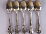 six spoons are lined up in a row on a white surface