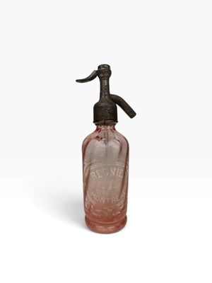 une bouteille en verre rose avec une poignée noire sur un fond blanc