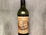 a bottle of wine that is sitting on a glass shelf