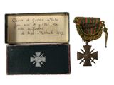 une vieille boîte sur laquelle figurent une médaille et une croix