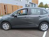 une petite voiture grise garée sur un parking