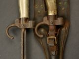 pair of antique brass - plated knife and sheaths on a gray background