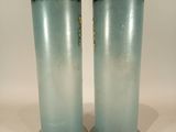 two tall vases sitting next to each other on a table