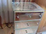 une commode en verre surmontée d'une lampe