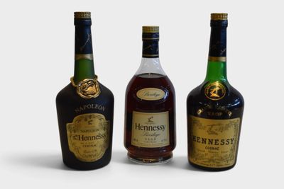 three bottles of liquor are lined up on a white surface