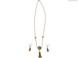 un collier et des boucles d'oreilles en or ornés de pompons, sur fond blanc
