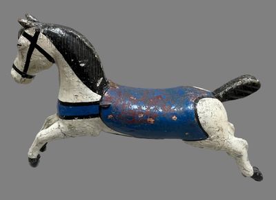 a small wooden horse with a blue blanket on it ' s back