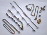 plusieurs types de colliers et de bracelets posés sur un fond blanc