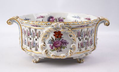 un bol blanc orné de fleurs, posé sur une table